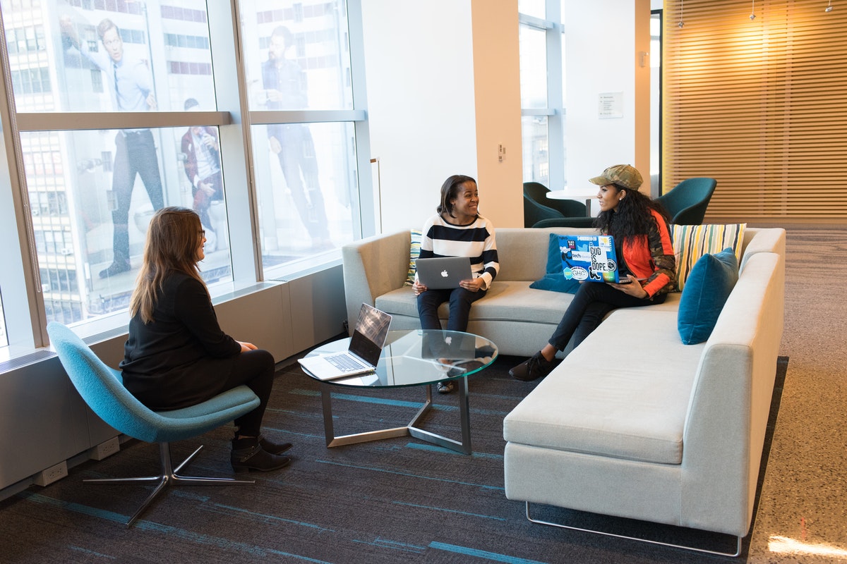 vrouwen zitten op de bank met laptops